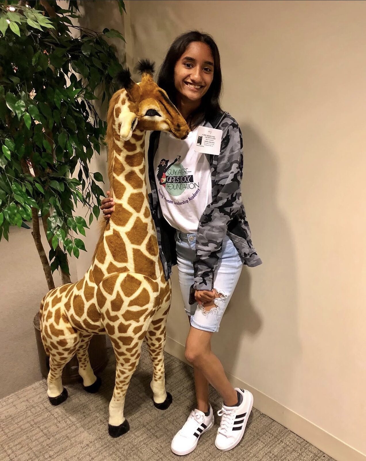All smiles beside a giraffe figure