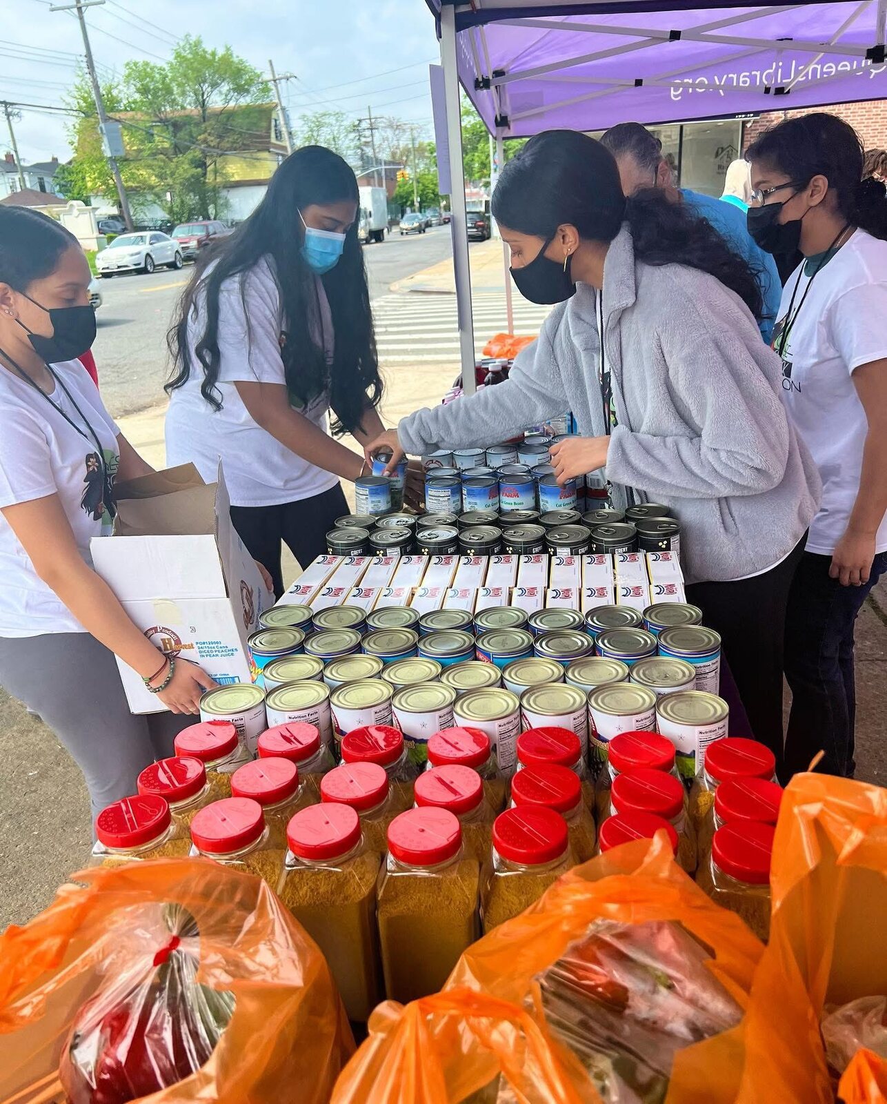 Stacking canned goods at a Queens Library food drive