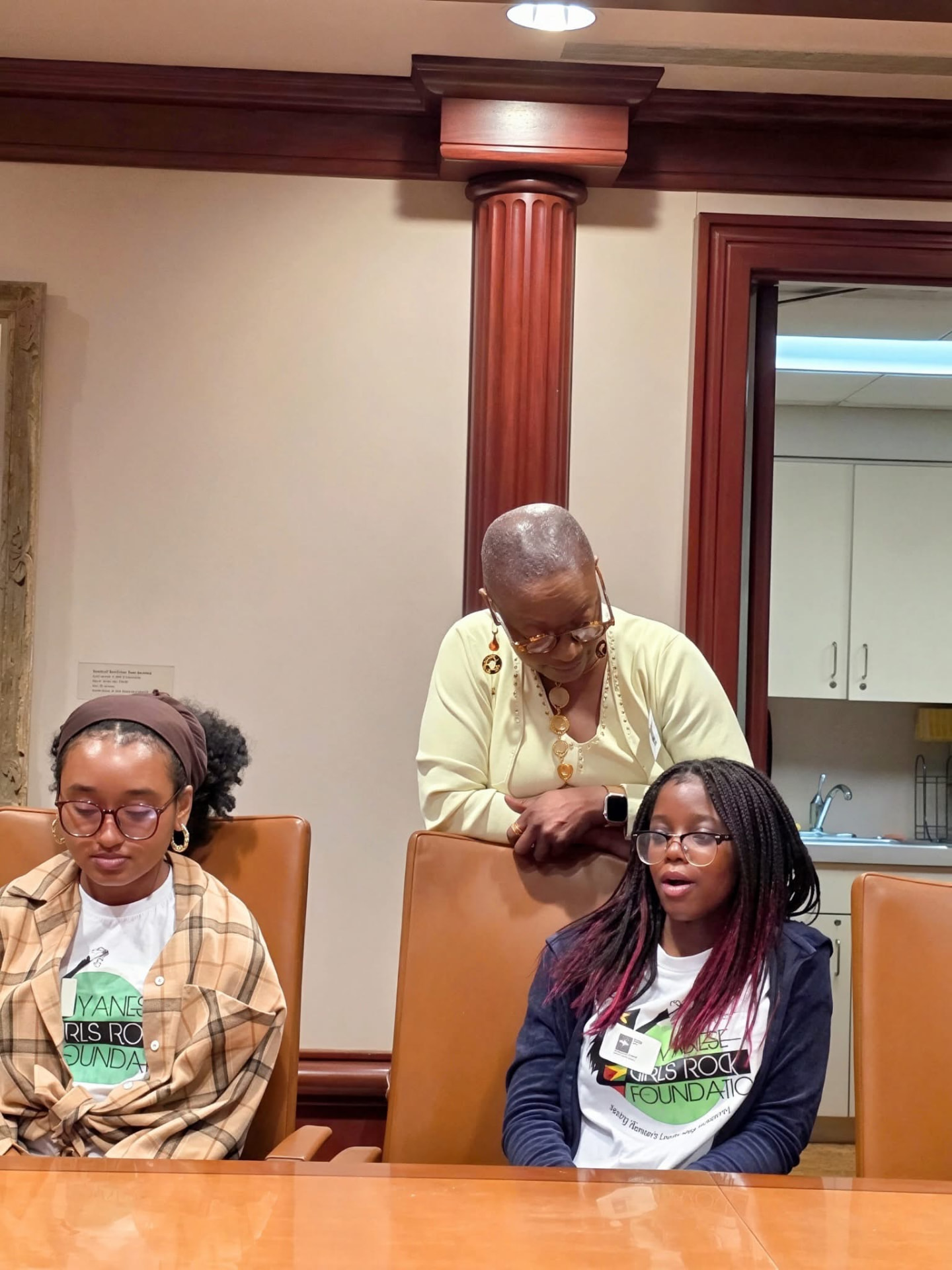 A mentor checks in with scholars at the meeting table