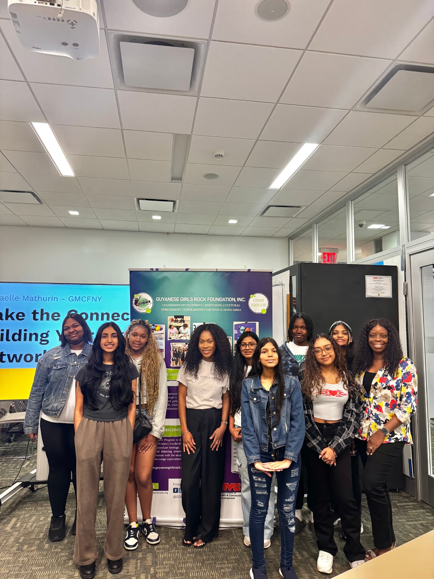 Scholars and mentors gather by the foundation banner after a networking workshop