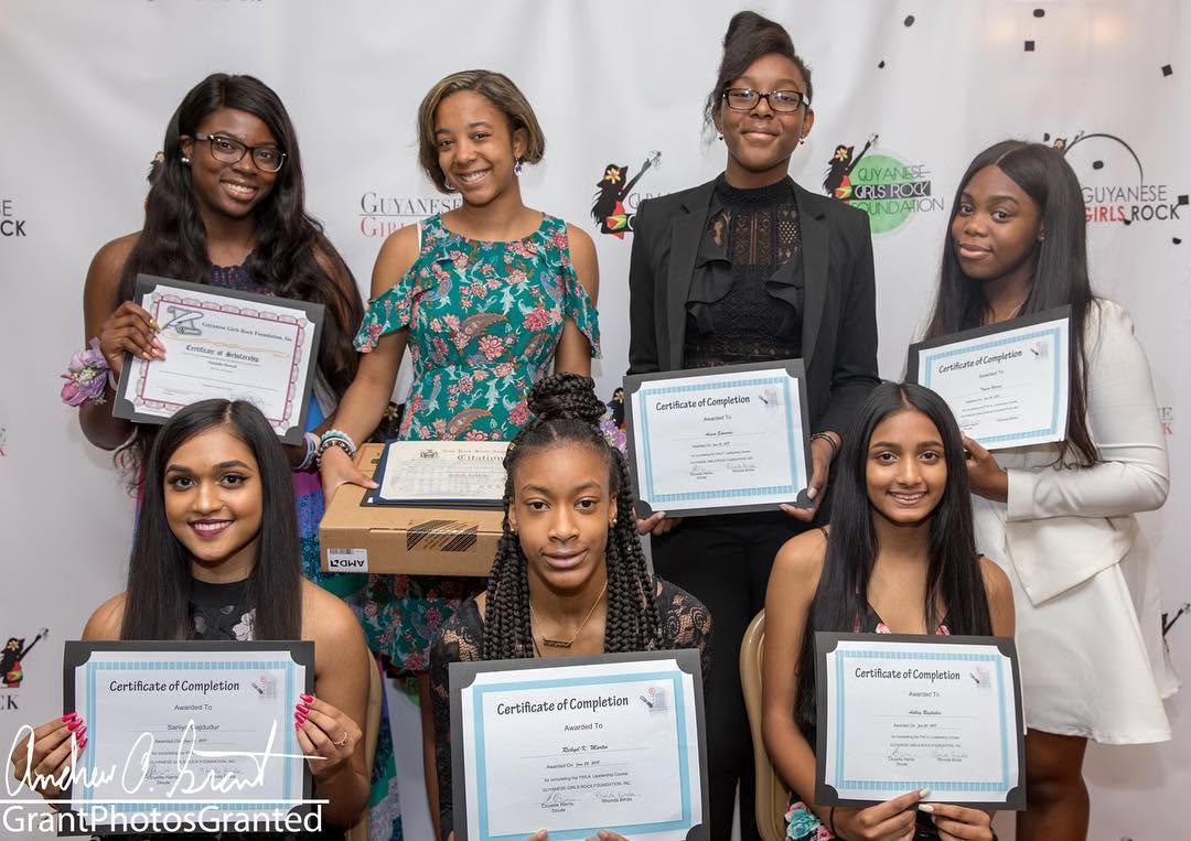 Scholars proudly holding their certificates