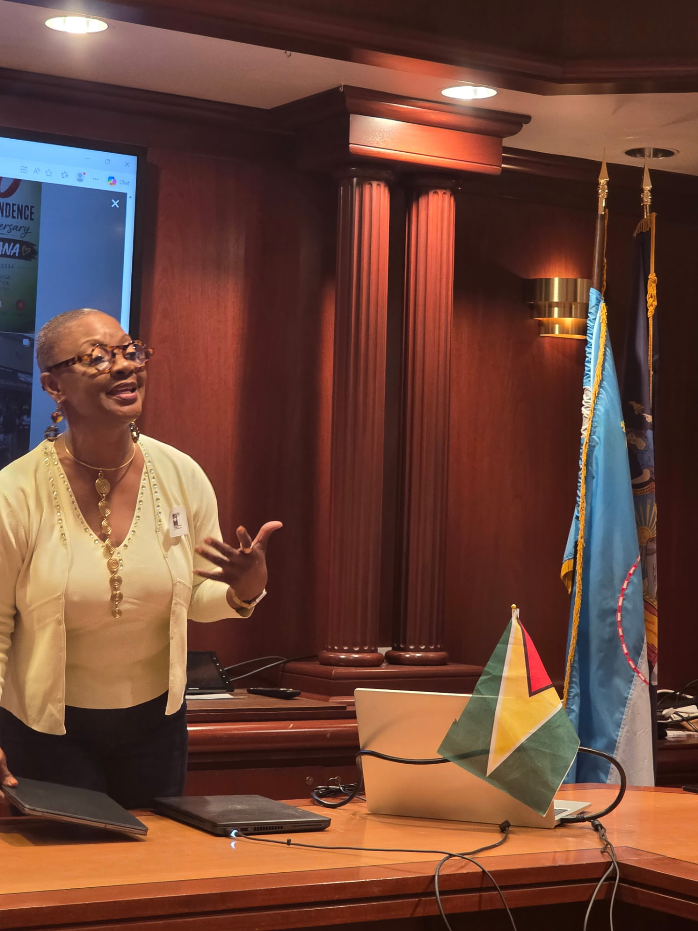A guest speaker beside the Guyana flag